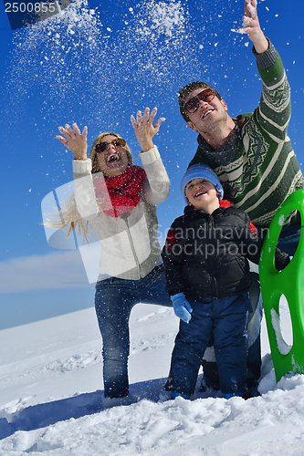 Image of family having fun on fresh snow at winter vacation