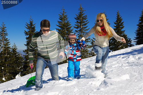 Image of family having fun on fresh snow at winter vacation