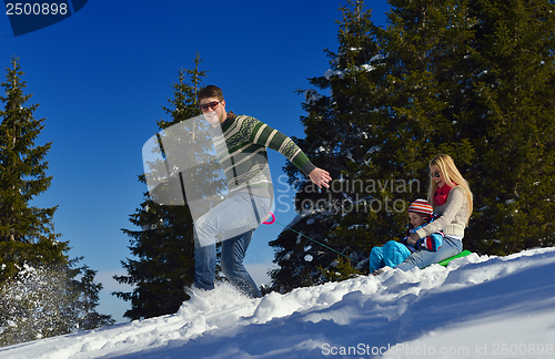 Image of family having fun on fresh snow at winter vacation