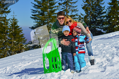 Image of family having fun on fresh snow at winter vacation