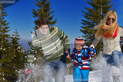 Image of family having fun on fresh snow at winter vacation
