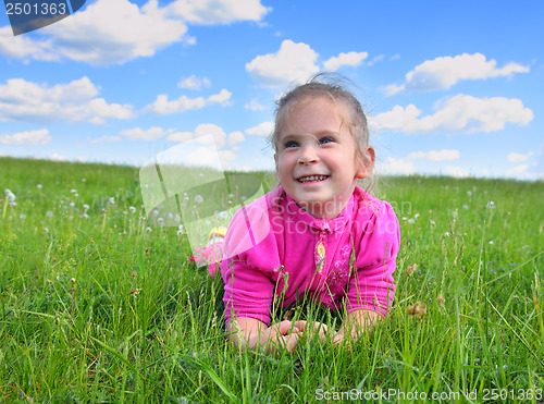 Image of happy little girl lying on grass