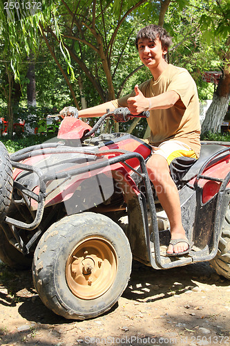 Image of happy asian boy on quad bike atv