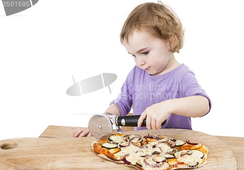 Image of cute girl cutting fresh homemade pizza