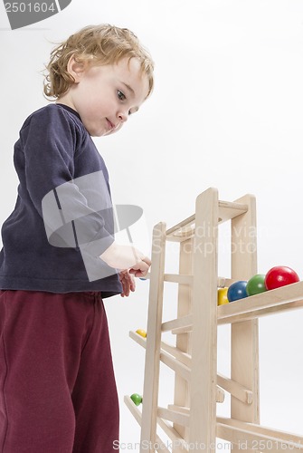 Image of child playing with wooden ball path
