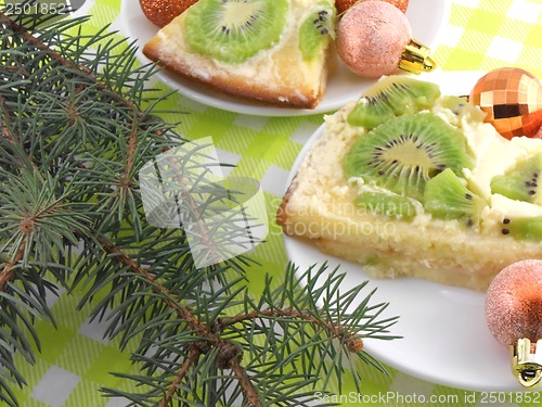Image of kiwi cake on plate with christmas balls and new year tree