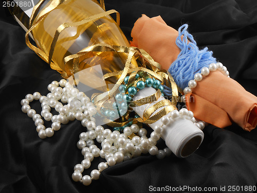 Image of bottle of champagne wine with white diamonds on black material background