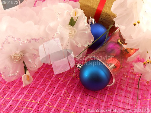 Image of Golden gift box with white flowers and christmas balls in glass