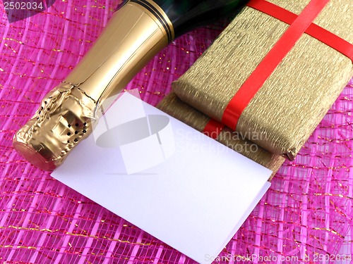 Image of champagne or wine bottle, blank paper and golden box, New Year or christmas card