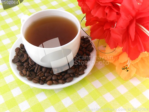 Image of Cup of coffee with coffee beans with flowers