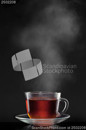 Image of cup with hot tea and steam on black