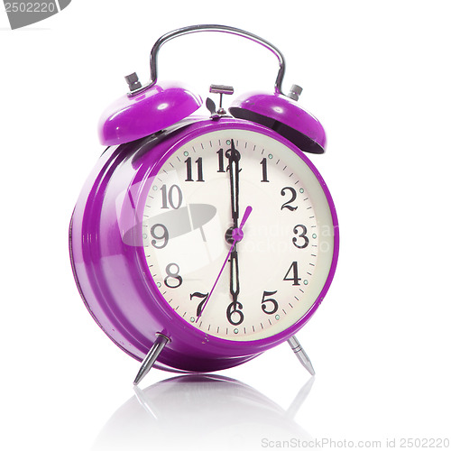 Image of pink old style alarm clock isolated on white