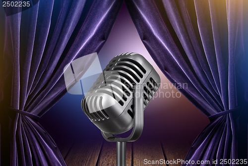 Image of stage with open curtains and microphone