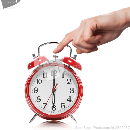 Image of hand and red old style alarm clock isolated on white