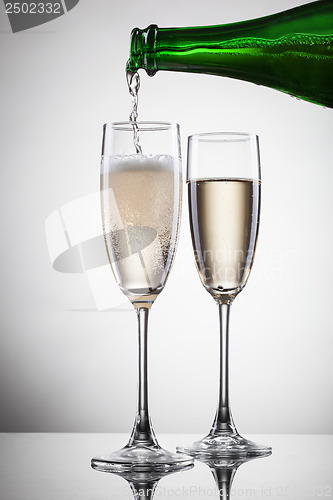 Image of Champagne pouring into glass isolated on white