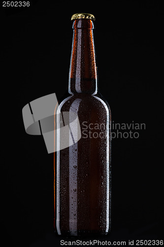 Image of Beer bottle with water drops isolated on black