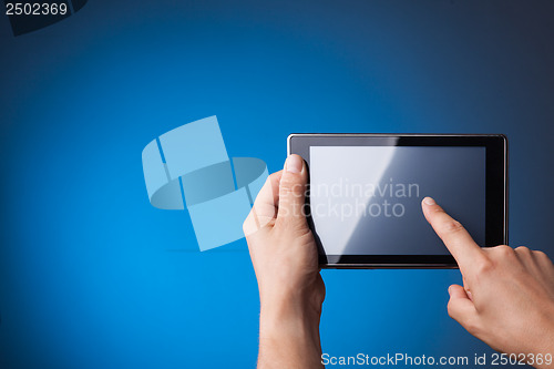 Image of Hands holding Tablet PC on blue