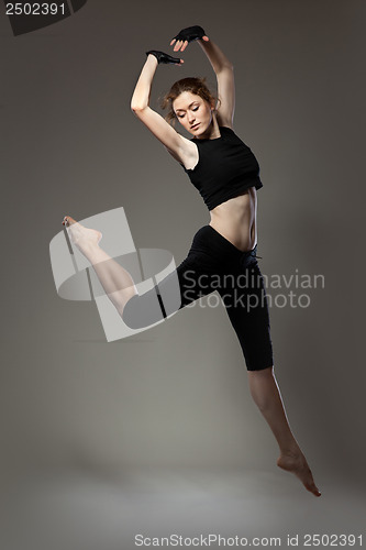 Image of jumping young dancer on black