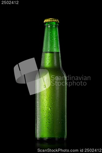 Image of beer bottle with water drops isolated on black