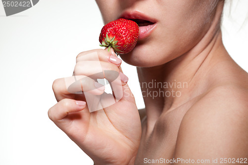 Image of Young woman biting strawberry isolated on white