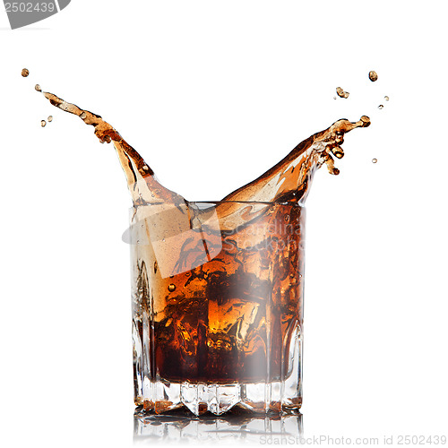 Image of splash of cola in glass with ice cubes isolated on white