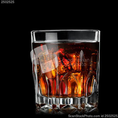 Image of cola with cognac in glass on black
