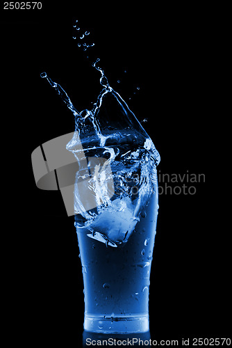 Image of water splash in glass isolated on black