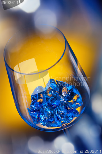 Image of ice in wineglass on color background