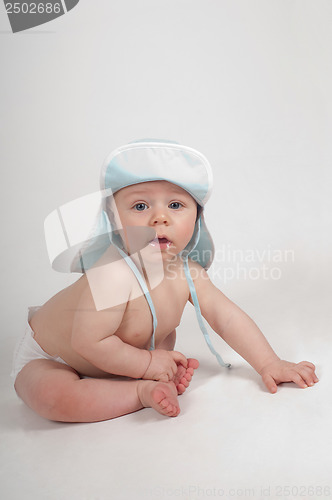 Image of Baby boy in blue hat sitting