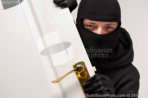 Image of Burglar sneaking in a open house door