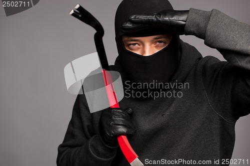 Image of Burglar with a crowbar on the shoulder.