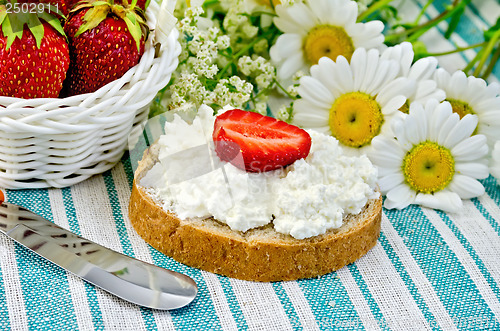 Image of Bread with curd cream and strawberries on a green napkin