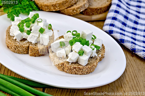 Image of Bread with feta cheese and green onions on a board