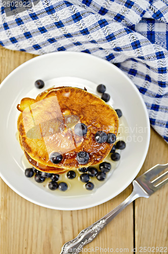 Image of Flapjacks with blueberries and a fork on a board