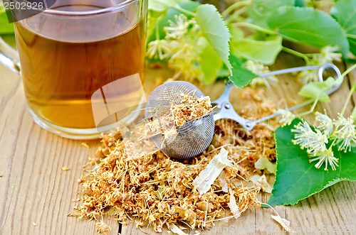 Image of Herbal tea from linden flowers in a tea strainer with mug