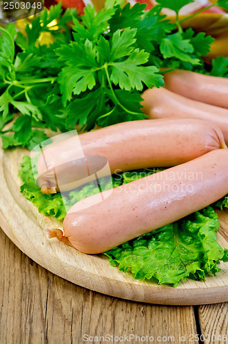 Image of Sausages on a board with parsley and oil