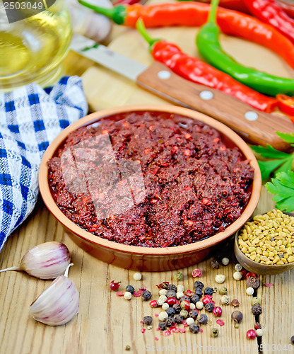 Image of Adjika with fresh hot peppers and spices on board