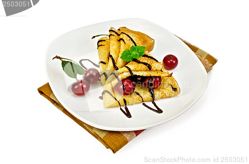 Image of Pancakes with cherry and chocolate syrup on a napkin