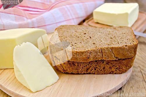 Image of Rye bread with cheese and butter on board