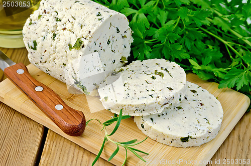 Image of Cheese homemade with herbs cut on a board