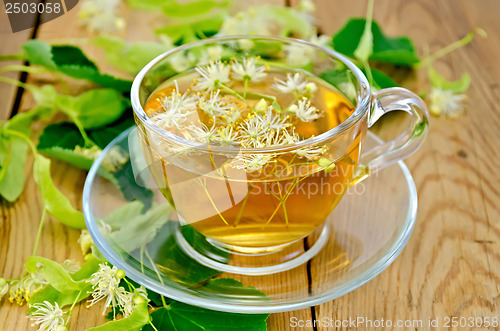 Image of Herbal tea from linden flowers in a cup on the board