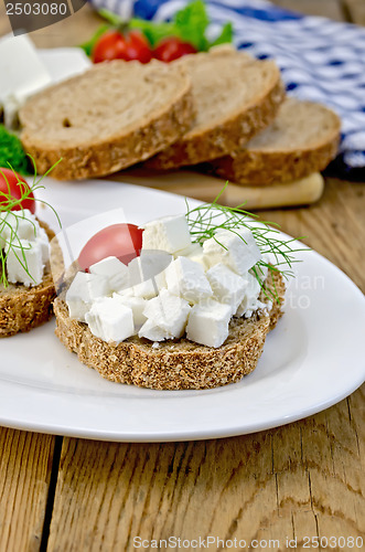 Image of Bread with feta cheese and tomatoes on the board