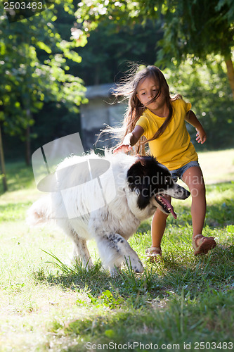 Image of Little girl with dog running