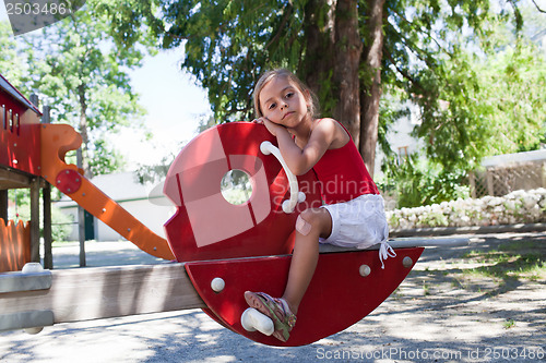 Image of Little girl on swing in summer park