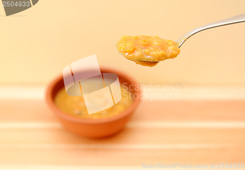 Image of Spoonful of vegetable soup above the bowl
