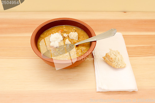 Image of Bowl of soup served with pieces of bread roll
