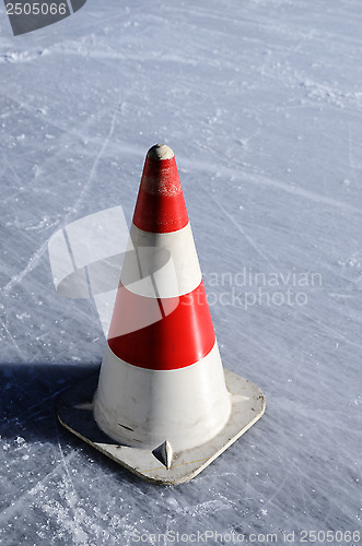 Image of red white striped cones on the ice rink