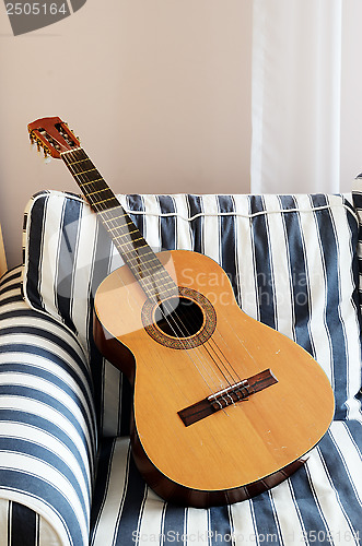 Image of acoustic guitar on a striped couch