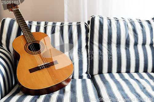 Image of acoustic guitar on a couch