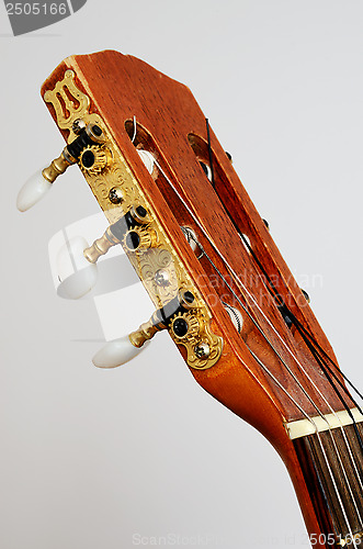 Image of head guitar neck with tuning pegs on gray